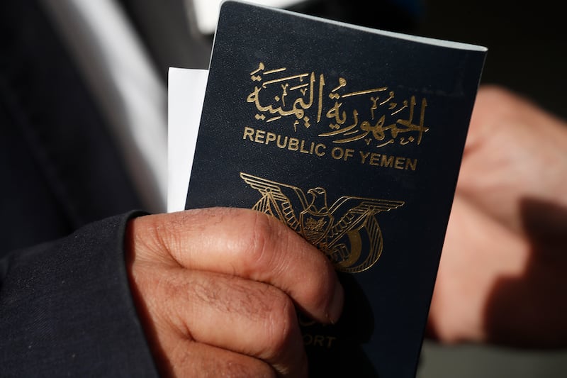 A passenger holds his passport as he arrives to board the Yemenia Airways plane. EPA
