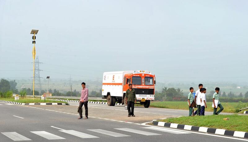 Indian Lambadi tribal students and villagers cross National Highway 44. Noah Seelam / AFP