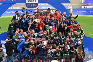 Inter Milan's Italian defender Danilo D'Ambrosio (Rear L) and Inter Milan's Italian midfielder Roberto Gagliardini hold the Scudetto Trophy as Inter players and staff celebrate winning the Serie A 2020-2021 championship after their last Italian Serie A football match Inter Milan vs Udinese on May 23, 2021 at the San Siro stadium in Milan. / AFP / MIGUEL MEDINA