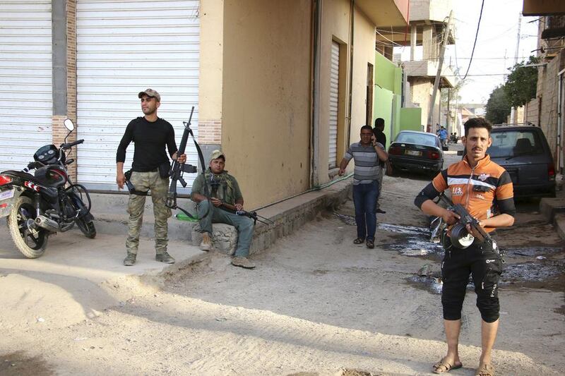 Sunni tribal fighters carry their weapons as they stand guard against attacks from ISIL militants in Ramadi on May 15. Reuters