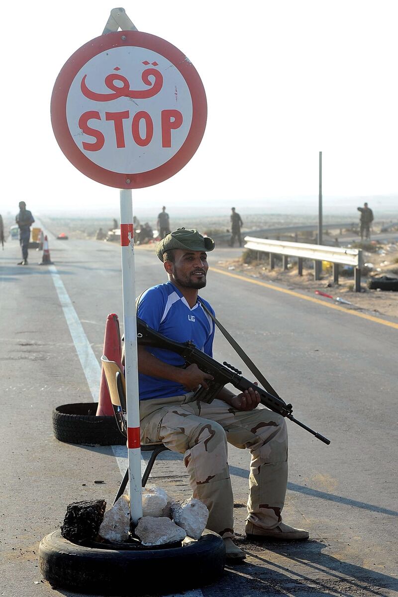 epa02881151 A Libyan rebel fighter guards a checkpoint near Ras Lanuf, east of Tripoli and Sirte, Libya, on 25 August 2011. Libyan rebel leader Mustafa Abdel Jalil said more than 20,000 people have died during the six-month-old rebellion to oust Muammar Gaddafi. Since February, rebels have been fighting Gaddafi's forces in a bid to end his 42 years in power.  EPA/MOHAMED OMAR *** Local Caption ***  02881151.jpg