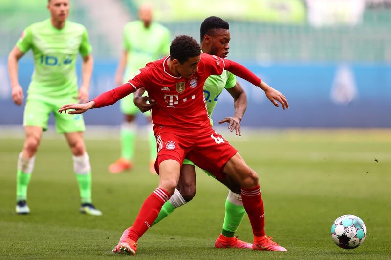 Bayern's Jamal Musiala under pressure from Ridle Baku of Wolfsburg. Getty