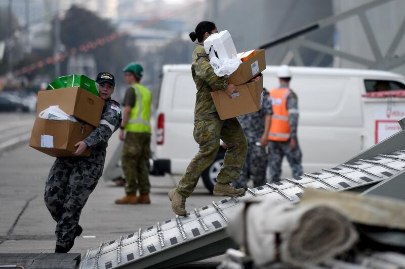 Army and Navy personal load supplies onto HMAS Adelaide as it prepares to leave Garden Island naval base to assist with the ongoing bushfire crisis, in Sydney, New South Wales. EPA