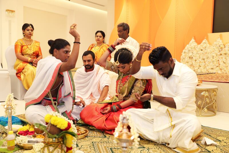 A priest explains prayers and rituals to the bride Iswarya Sundararajan and groom Arvindh Selvam during their marriage ceremony at the Hindu temple in Jebel Ali, Dubai. All photos: Pawan Singh / The National