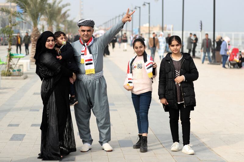 Iraqi fans pose for a picture near a designated fan zone at the semi-finals between Iraq and Qatar. AFP