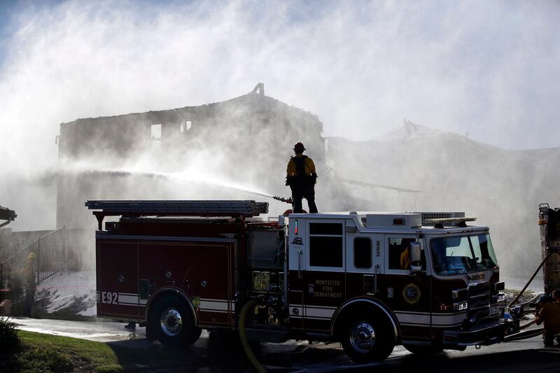 A firefighter tries to put out a residence fire caused by a wildfire from atop a fire truck Friday, Oct. 25, 2019, in Santa Clarita, Calif. An estimated 50,000 people were under evacuation orders in the Santa Clarita area north of Los Angeles as hot, dry Santa Ana winds howling at up to 50 mph (80 kph) drove the flames into neighborhoods(AP Photo/Marcio Jose Sanchez)