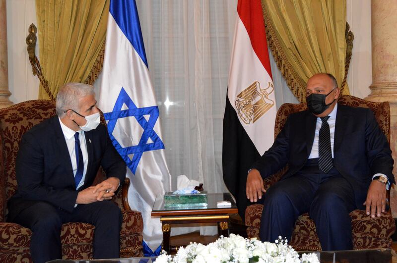Egyptian Foreign Minister Sameh Shoukry, right, meets Israeli Foreign Minister Yair Lapid in Cairo. Mr Lapid is visiting to discuss with Egyptian officials the ceasefire with Gaza militants and the Israeli economic recovery plan for Gaza, among other topics.  EPA