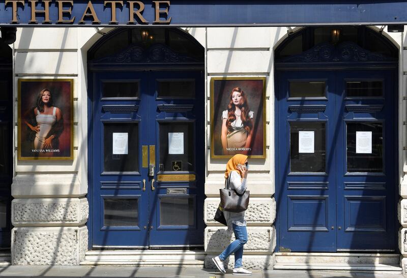 A woman wearing a protective face mask walks past a closed theatre, as the spread of the coronavirus disease (COVID-19) continues, in London, Britain June 23, 2020. REUTERS/Toby Melville
