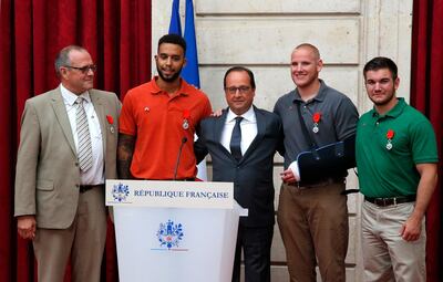 French President Francois Hollande (C) poses with (LtoR) British businessman Chris Norman and off-duty US servicemen Anthony Sadler, Spencer Stone, and Alek Skarlatos during a reception in their honor at the Elysee Palace on August 24, 2015 in Paris, after Hollande awarded them with France's top Legion d'Honneur medal in recognition of their bravery after they overpowered the train attacker. AFP PHOTO / POOL / MICHEL EULER / AFP PHOTO / POOL / MICHEL EULER