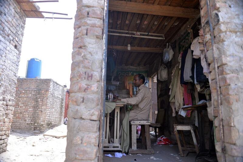 Pakistani Christian tailor Akram Mashi making dresses at his shop in a slum in Islamabad. Aamir Qureshi / AFP