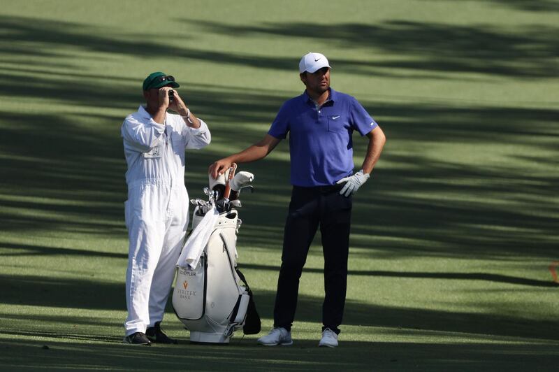 Scottie Scheffler  talks with his caddie on the 13th hole during a practice round prior to the Masters. AFP