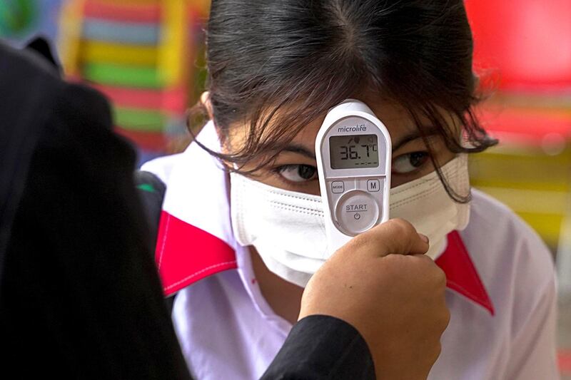 A student from the Sovannaphumi school has her temperature checked in Phnom Penh, Cambodia. Reuters