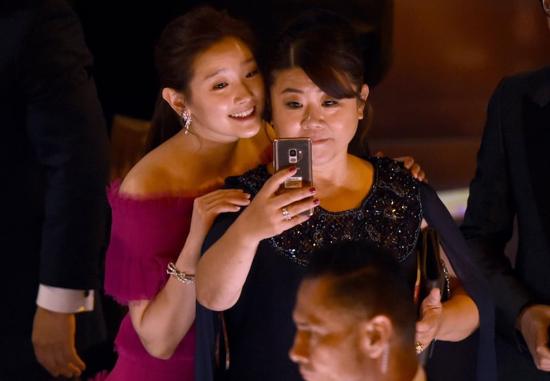 Park So-dam, left, and Lee Jeong-eun take a selfie as they appear on stage to accept the award for best picture for "Parasite" at the Oscars on Sunday, Feb. 9, 2020, at the Dolby Theatre in Los Angeles. (AP Photo/Chris Pizzello)