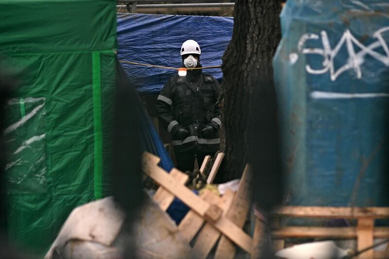 A security official looks out from the site of the protest camp. AFP