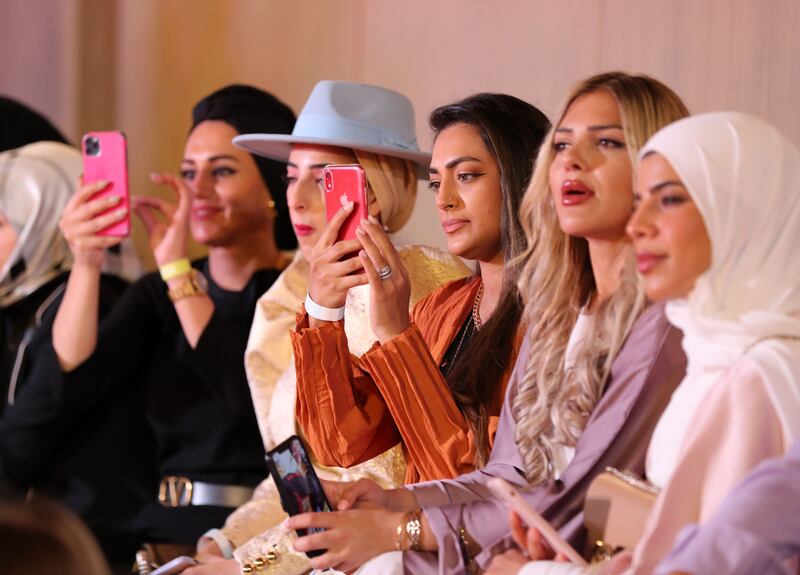 Phones at the ready - fashion fans take in the action.