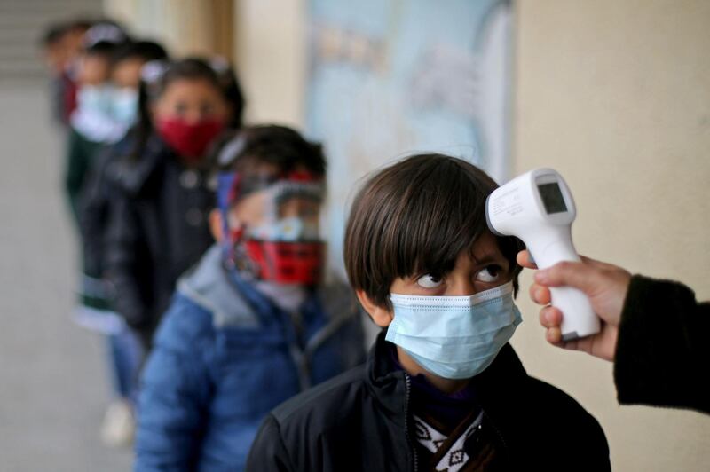 A Palestinian student has his temperature checked after his school reopened following the easing of coronavirus restrictions, in the southern Gaza Strip. Reuters