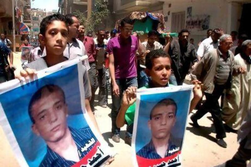 Egyptian boys hold posters of Ahmed Hussein Eid, a university student who was fatally stabbed by three bearded men in front of his girlfriend.