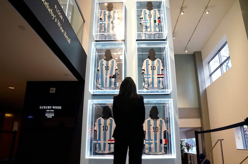 A visitor looks at the six World Cup match-worn shirts belonging to Messi at Sotheby's New York. AFP