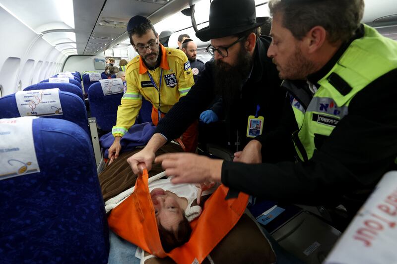 Officials tend to a patient on a plane carrying Ukrainian Jewish refugees as they wait to disembark at Israel's Ben Gurion Airport near Tel Aviv. AFP