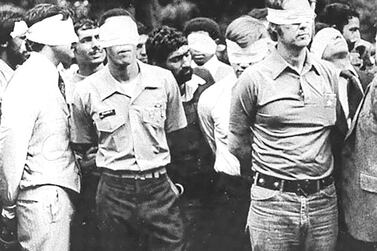 Blindfolded US hostages and their Iranian captors outside the US embassy in Tehran in 1979. US Army via Reuters