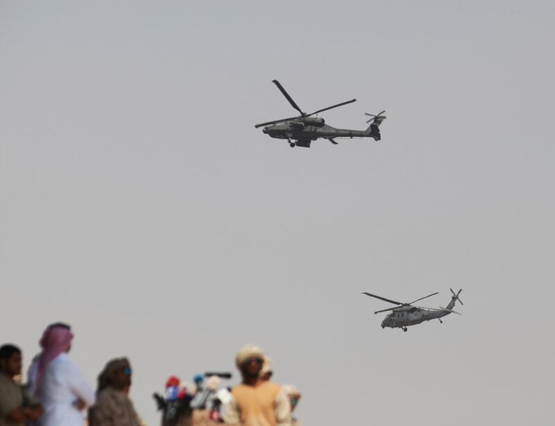 A Blackhawk helicopter and an Apache attack helicopter fly overhead during the military ceremony. AP Photo