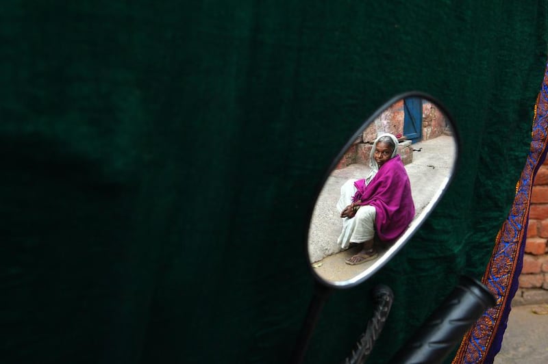 Cured leprosy patient Bhangarauva, 60, is seen in the reflection of a side mirror on a motorbike.