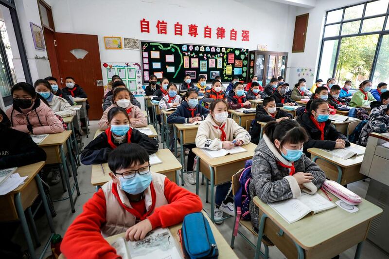 Elementary school students wearing face masks attend a class as they return to school after the start of the term was delayed in Huaian in China's eastern Jiangsu province. AFP