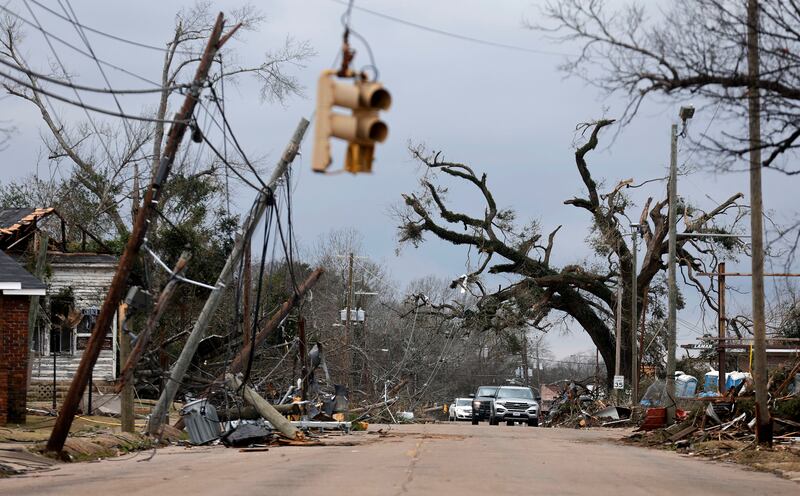 Cars carefully navigate downed trees and power lines on in Selma. AP