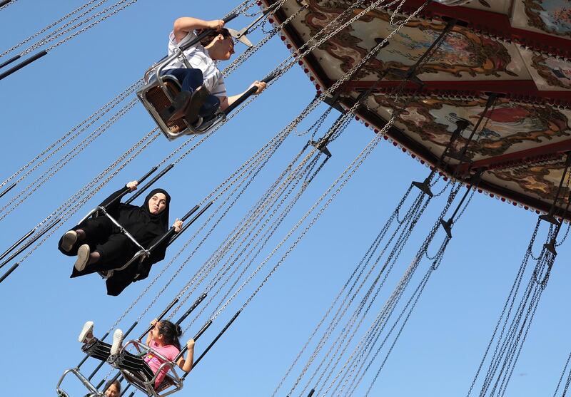 People enjoy a leisure ride at a fun fair during Eid-al-Adha holiday in Istanbul, Turkey.  EPA