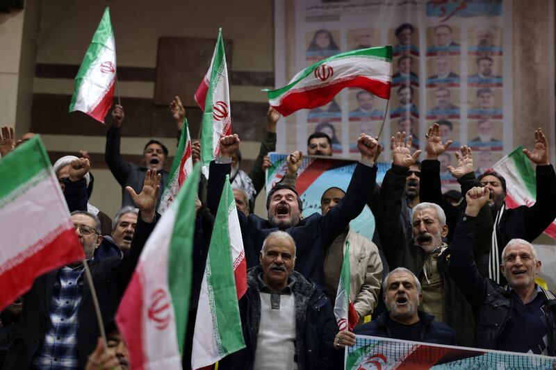 People chant slogans as they attend a rally at a sports stadium, in Tehran. AFP