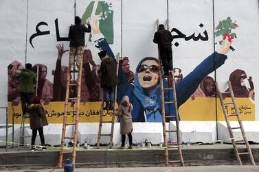 Artists paint a mural on a barrier wall at the Ministry of Women's Affairs to mark International Women's Day in Kabul, Afghanistan. AP