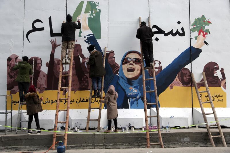 Independent Afghan artists draw a graffiti on a barrier wall of the Ministry of Women's Affairs to mark International Women's Day in Kabul, Afghanistan, Friday, March 8, 2019. (AP Photo/Rahmat Gul)