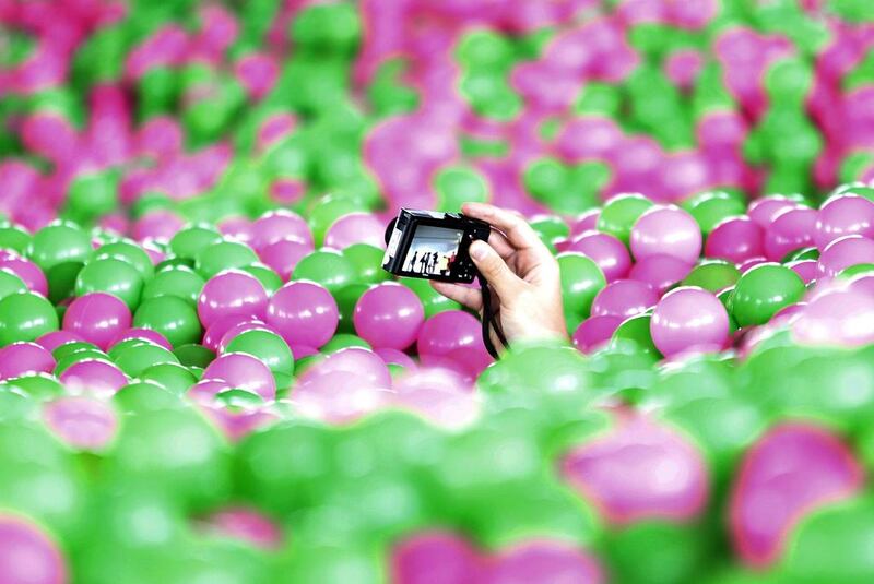 A participant takes pictures with a camera in a swimming pool filled with pink and green plastic balls during a Guinness World Record attempt of the Largest Ball Pit as part of the "Pink October" campaign at Kerry Hotel in Pudong, Shanghai. Aly Song / Reuters