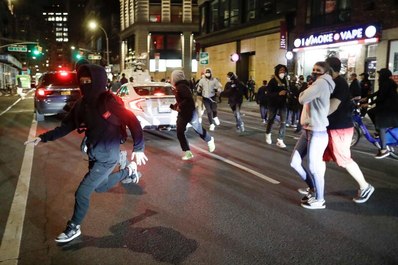 People being chased by police run past pedestrians near Union Square, in New York. AP Photo