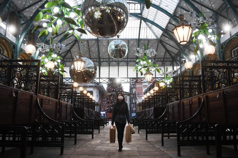 A woman passes Christmas decorations at Covent Garden in London. EPA