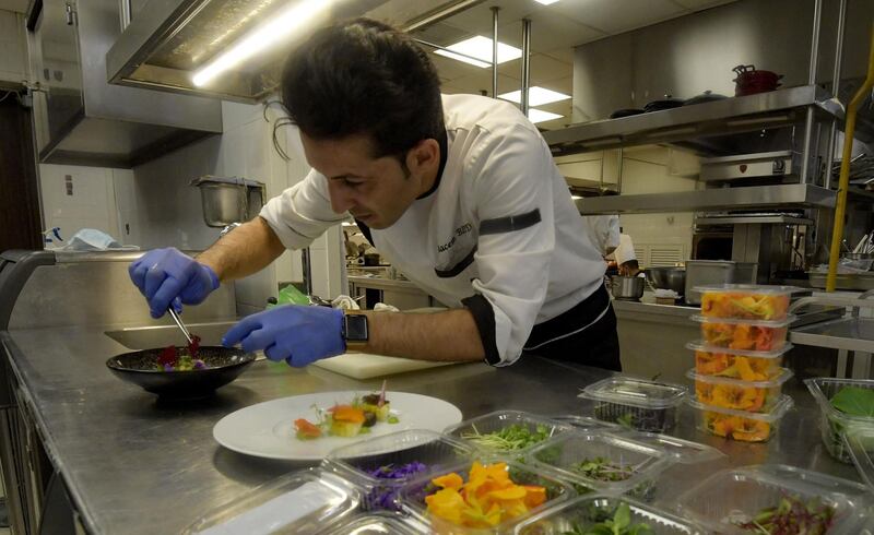 Chef Bassem Bizid places edible flowers on a dish. Adding fresh flowers to dishes ranging from soups to salads is a recent development in Tunisian cuisine. AFP