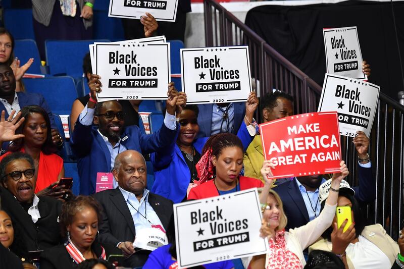 Herman Cain (C,L) and supporters of US President Donald Trump "Black Voices" listen to him speak during a campaign rally at the BOK Center on June 20, 2020 in Tulsa, Oklahoma. - Hundreds of supporters lined up early for Donald Trump's first political rally in months, saying the risk of contracting COVID-19 in a big, packed arena would not keep them from hearing the president's campaign message. (Photo by Nicholas Kamm / AFP)