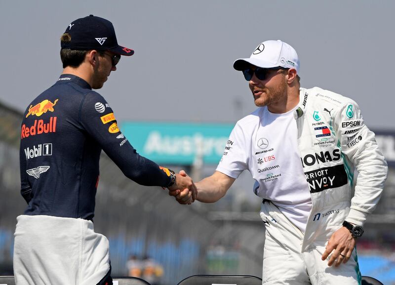 Mercedes driver Valtteri Bottas of Finland, right, shakes hands with Red Bull driver Pierre Gasly of France before they pose for a group photo ahead of the Australian Formula 1 Grand Prix in Melbourne, Australia. AP Photo