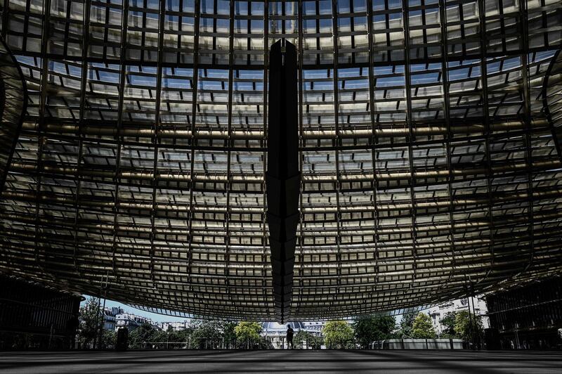 A man walks under the undulating glass canopy of the Forum de Halles shopping centre in central Paris.  AFP