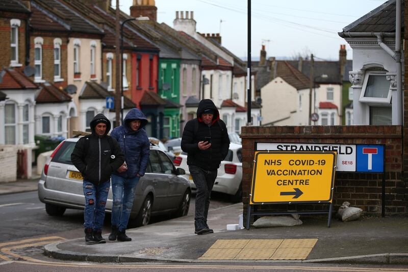 LONDON, ENGLAND - FEBRUARY 14: Pedestrians walk past a sign pointing towards a COVID-19 vaccination centre in Plumstead on February 14, 2021 in London, United Kingdom. Starting Monday, the UK's vaccination campaign will include everyone over the age 65. The country has prioritised its oldest citizens first, as well as frontline health workers and those who provide elder care. (Photo by Hollie Adams/Getty Images)