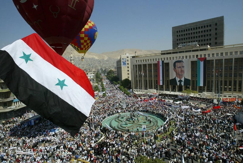 (FILES) In this file photo taken on May 24, 2007, Syrians gather in the capital  Damascus during President Bashar al-Assad's campaign for a no-contest referendum. - President Bashar al-Assad, whose family has ruled Syria for over half a century, faces an election this week meant to cement his image as the only hope for recovery in the war-battered country, analysts say. (Photo by Louai Beshara / AFP)