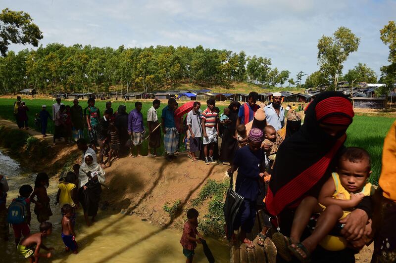 Rohingya refugees cross a small bridge at Kutupalong refugee camp in Bangladesh's Ukhiya district on September 9, 2017.
Nearly 300,000 Rohingya Muslims have fled Myanmar's Rakhine state into Bangladesh in the 15 days since new violence erupted, the United Nations said September 9. The figure has jumped about 20,000 in a day. Munir Uz Zaman / AFP