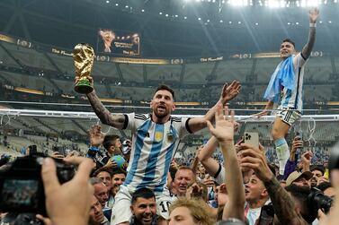 Argentina's Lionel Messi celebrates with the trophy in front of the fans after winning the World Cup final soccer match between Argentina and France at the Lusail Stadium in Lusail, Qatar, Sunday, Dec. 18, 2022. Argentina won 4-2 in a penalty shootout after the match ended tied 3-3. (AP Photo/Martin Meissner)