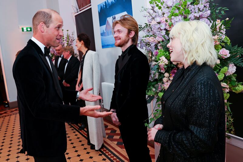 Prince William, left, speaks with performers Finneas O'Connell and Billie Eilish at the world premiere of 'No Time to Die' in London on September 28, 2021. AP