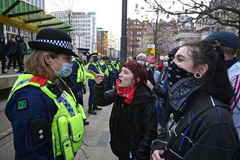 Police officers wearing protective face coverings face a crowd of demonstrators protesting against the Police, Crime, Sentencing and Courts Bill 2021 in central Manchester. AFP