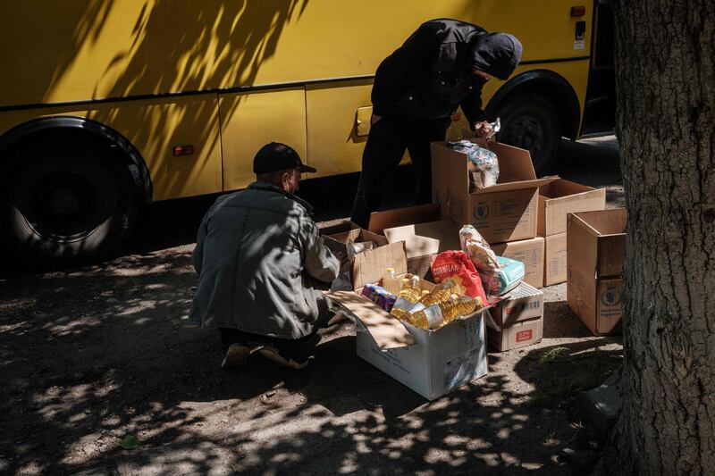 Volunteers deliver food supplies to residents, taken from the warehouse of a humanitarian aid distribution centre in Severodonetsk. AFP