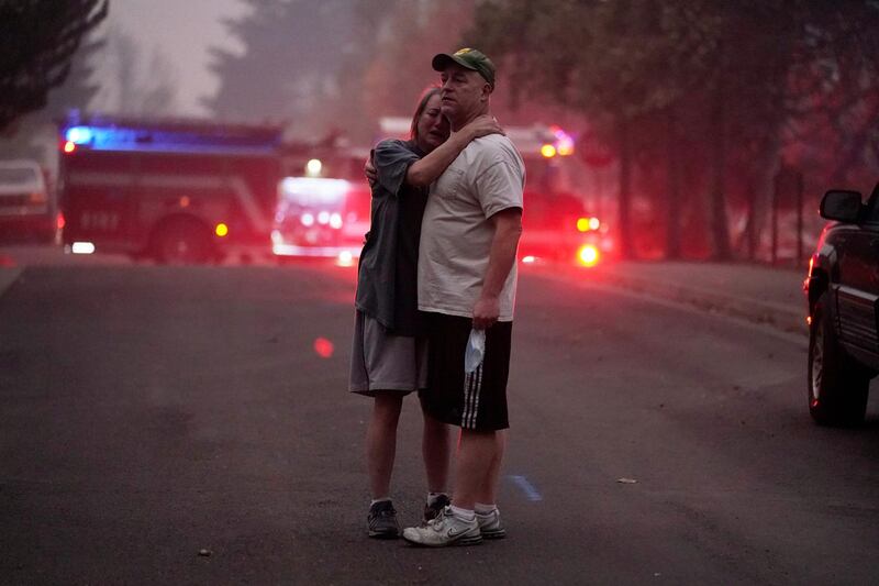 A couple embrace while touring in an area devastated by the Almeda Fire in Phoenix, Oregon. AP Photo