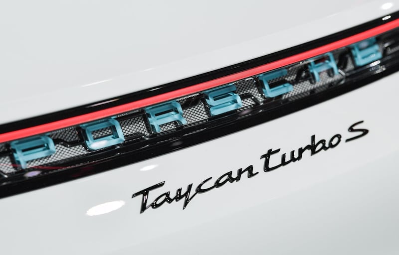 The logo of a Porsche Taycan turbos S electric car is seen during its presentation. AFP