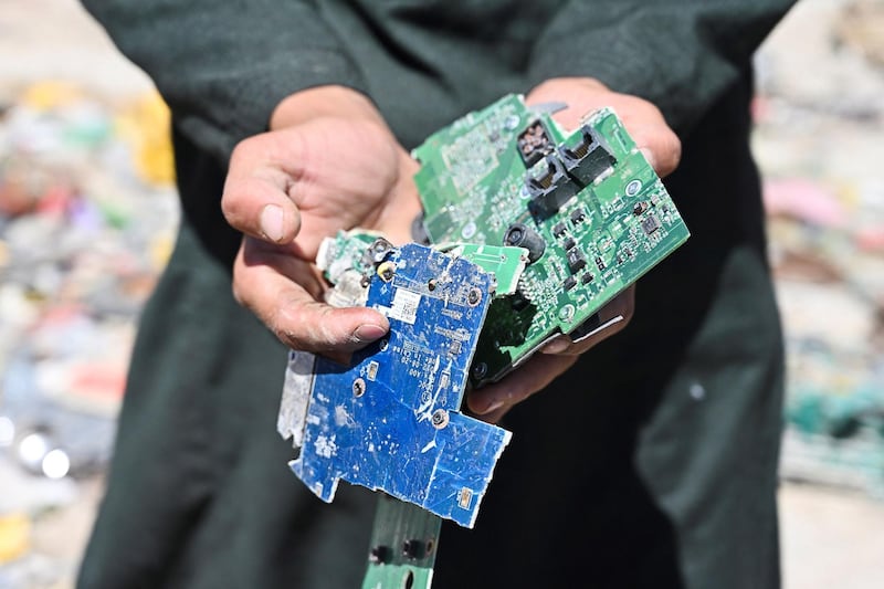 A man shows electronic motherboards at a junkyard near the Bagram Air Base. AFP