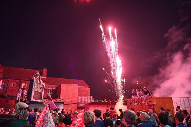 Fans celebrate Liverpool winning the Premier League title outside Anfield stadium. AFP